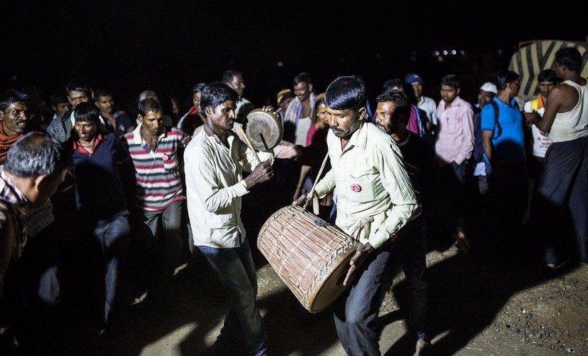 After a long day of walking, some farmers sing and dance at night; others like Waghere are exhausted; soon, everyone rests for the night under the open sky. Image courtesy: PARI