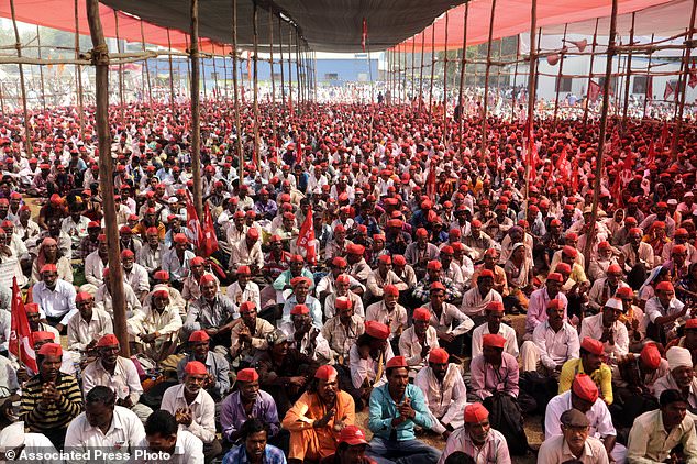 Thousands of farmers listen to their leader at the end of their six day long march on foot, in Mumbai, India, Monday, March 12, 2018. Tens of thousands of farmers from across western India have arrived in Mumbai demanding, among other things, a waiver of farm loans and fair prices for their produce as India's agriculture sector struggles amid years of declining earnings. The farmers reached India's business capital Monday after marching on foot for up to six days and plan to surround the state legislature of the western state of Maharashtra in Mumbai. (AP Photo/Rajanish Kakade)